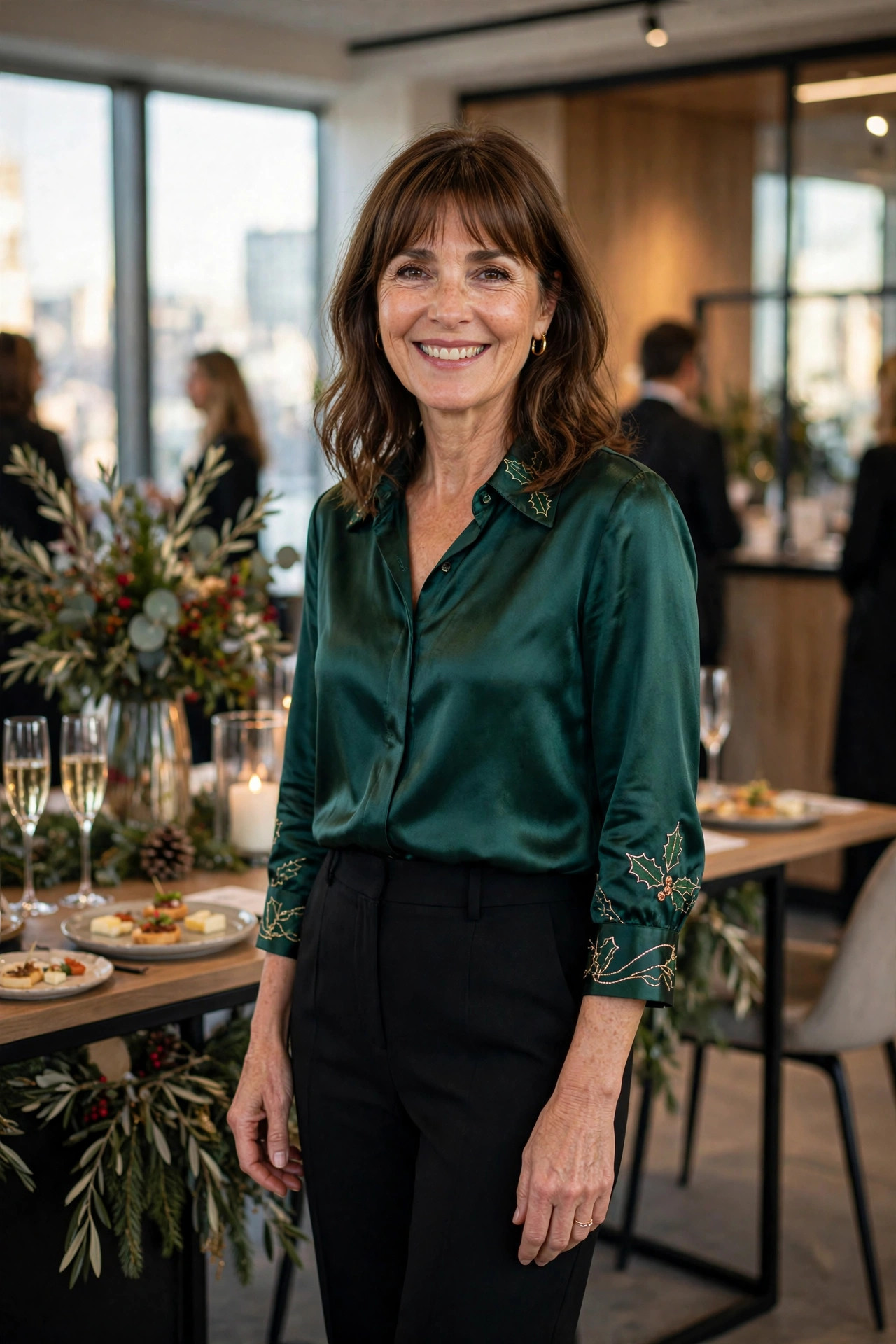 Smiling woman wearing an emerald satin blouse with black trousers at a work event reception